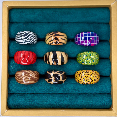 Set of colorful rings in a wooden box with teal cushioning