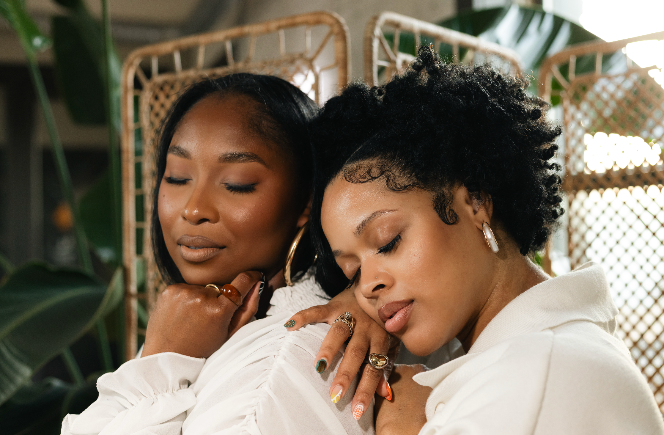 Two women in white shirts sitting close together with a blurred background | B. Marie Accessories, Shannon Johnson, DMV