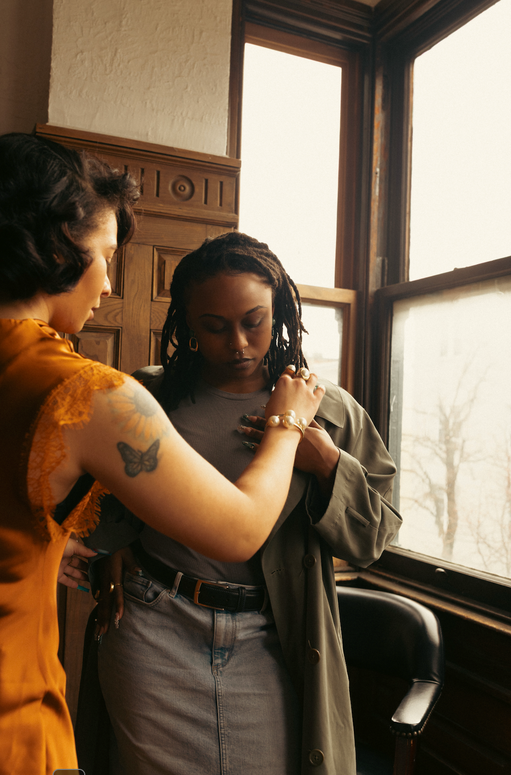 Two women standing close together in a room with large windows. | B. Marie Accessories, Shannon Johnson, DMV